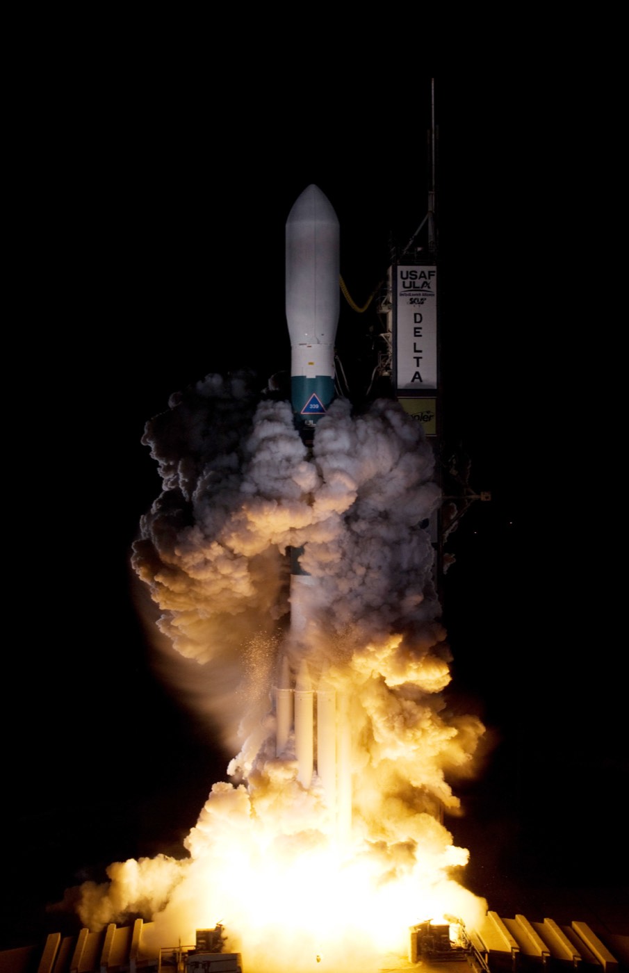 Rocket lifting off from a launch pad at night