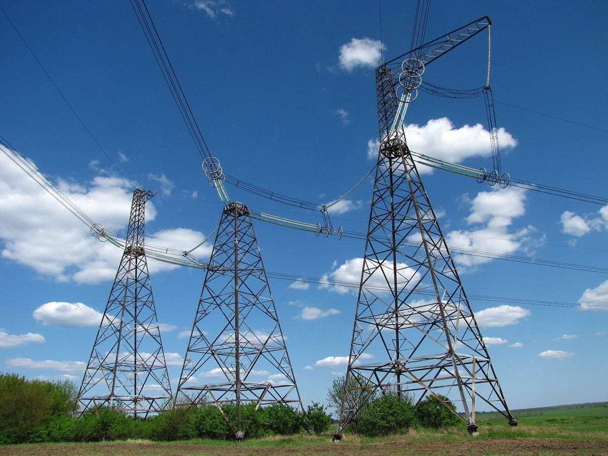 High-voltage transmission pylons against a blue sky